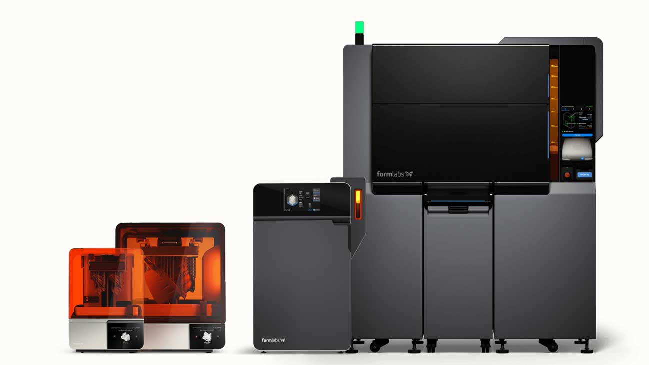 3D printer setup with multiple components, including a monitor and resin tanks.